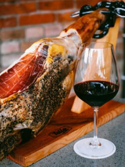 Sardines in a tin with greens and bread on a white plate, perfect for gourmet cuisine.